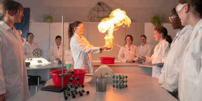 teacher showing the student a science project in the form of flames