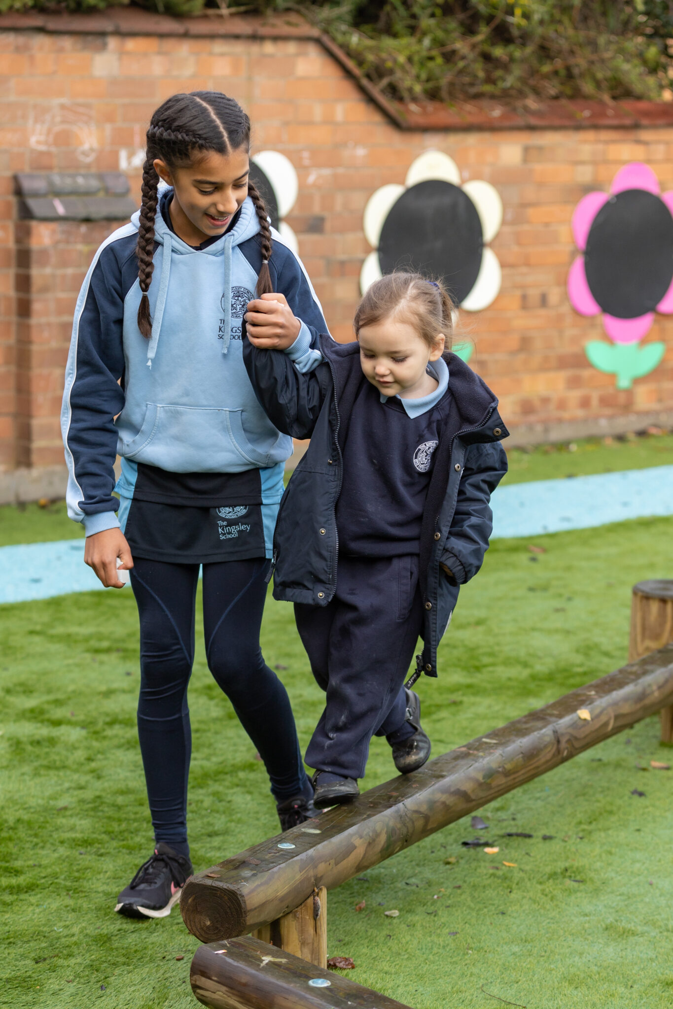 student helping a girl on a beam